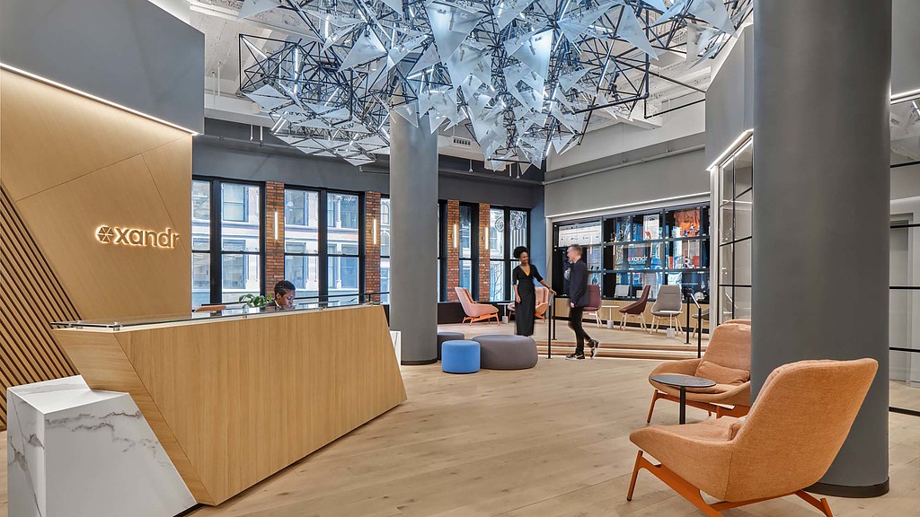 A couple of people in a large room with chairs and a large glass ceiling.