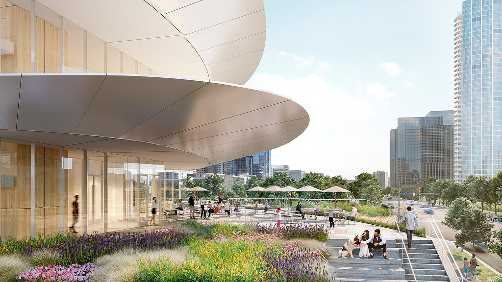 A large building with a courtyard and people walking around.