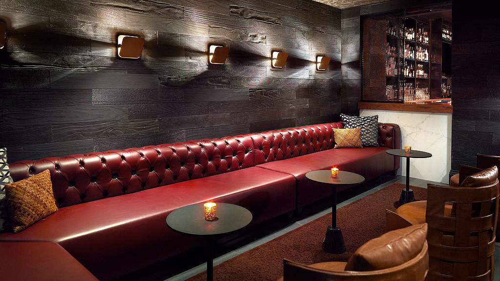 A red couch with candles on it.