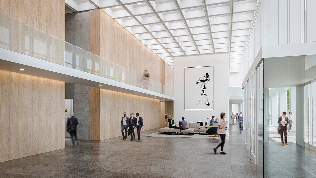 A group of people in a large room with a large white wall.