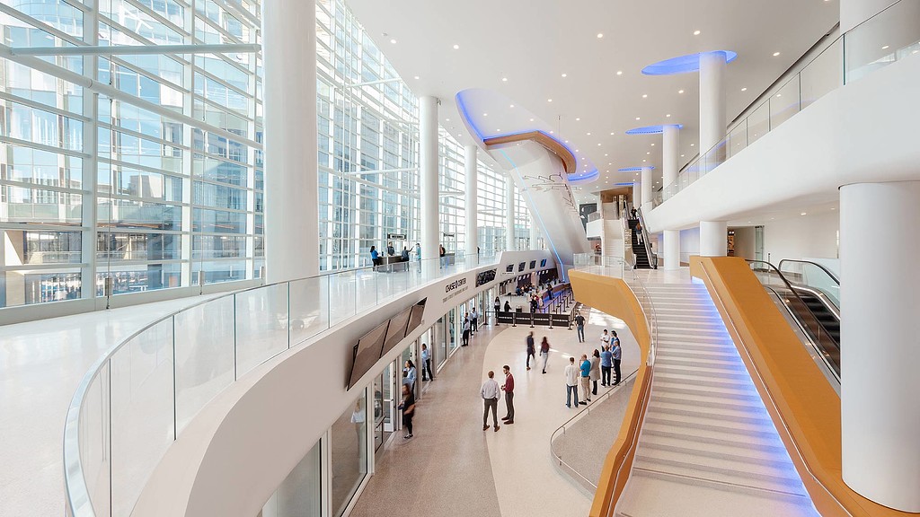A group of people walking down a long hallway.
