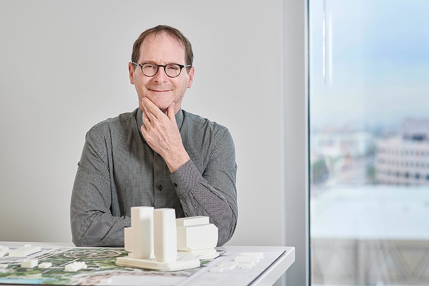 A man sitting at a table with his hand on his chin.