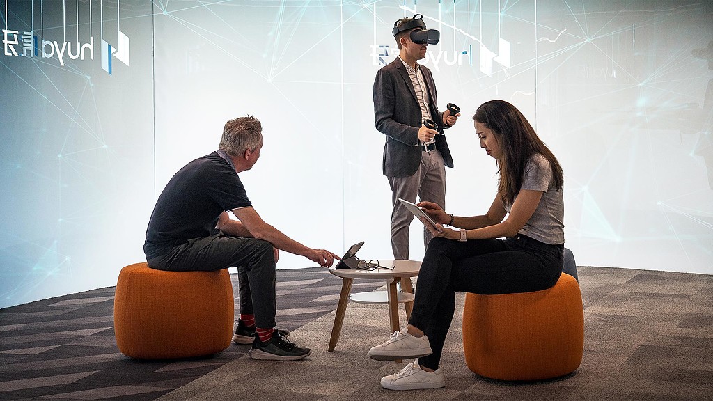 A group of people sitting on orange chairs.