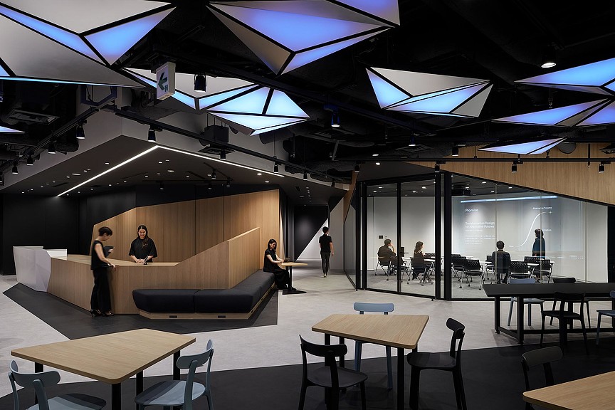 A group of people in a room with tables and chairs.