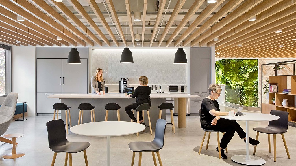 A group of people sitting at a table in a room with a large window.