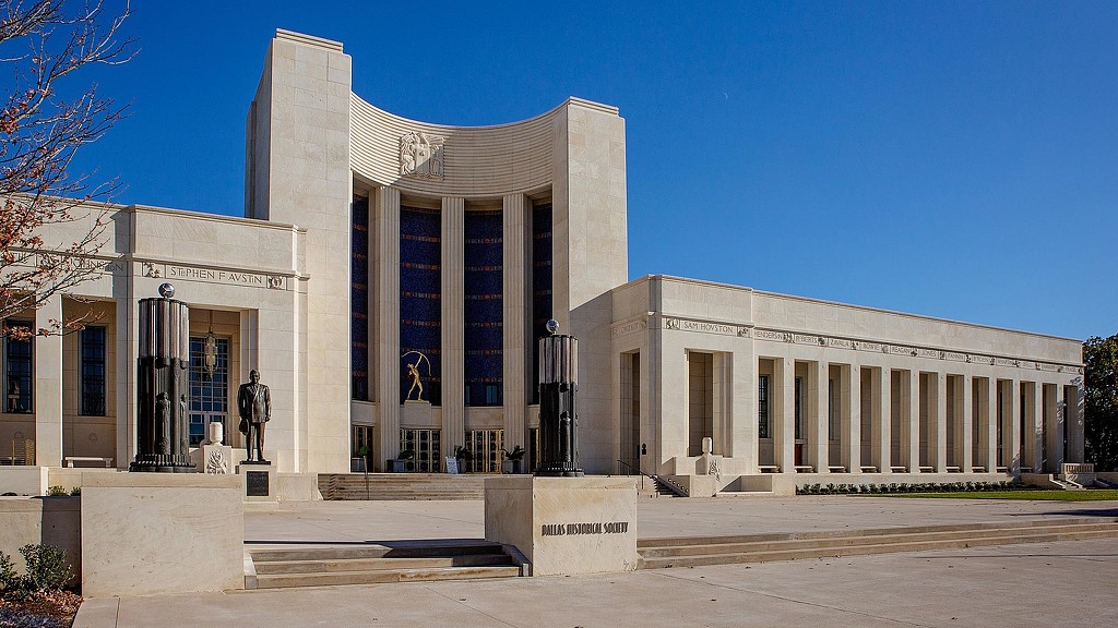 A large white building with columns with National Gallery of Art in the background.