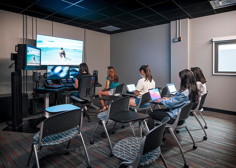 A group of people sitting in a room with computers.