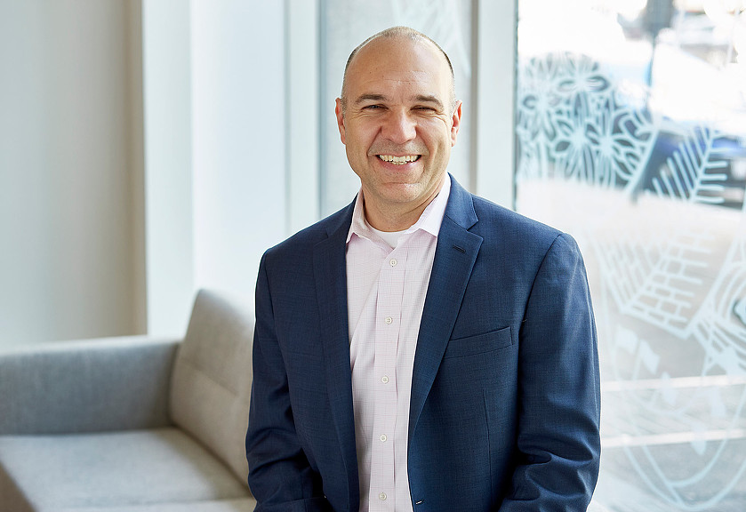 A man in a suit smiling.