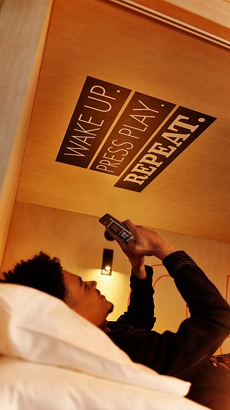 A man lying on a bed with a phone in his hand.
