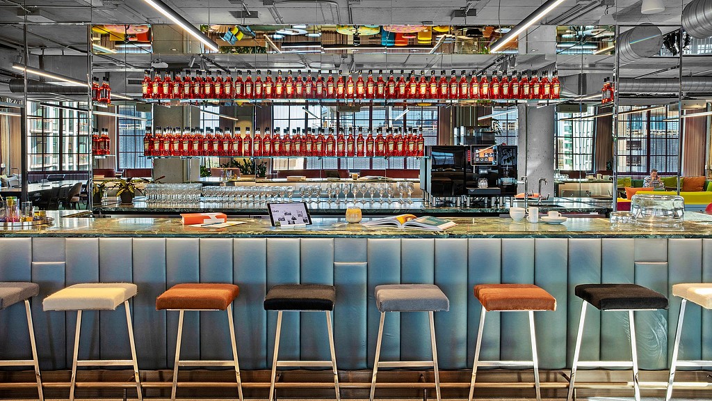 A bar with stools and a bar behind it.