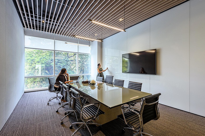 A person standing in a room with a table and chairs.