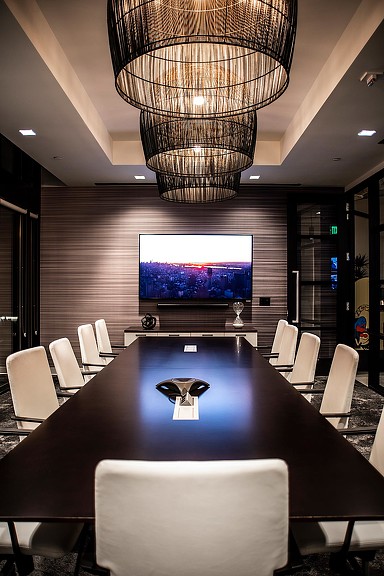 A conference room with a large projector screen and chairs.