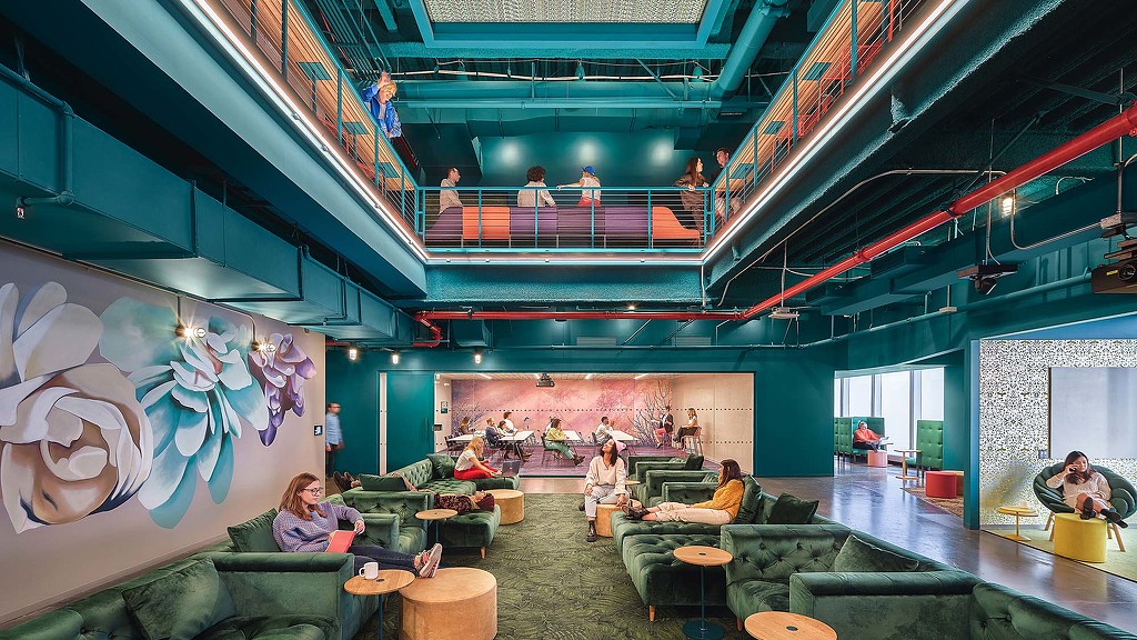 A group of people sitting in a room with a large screen.