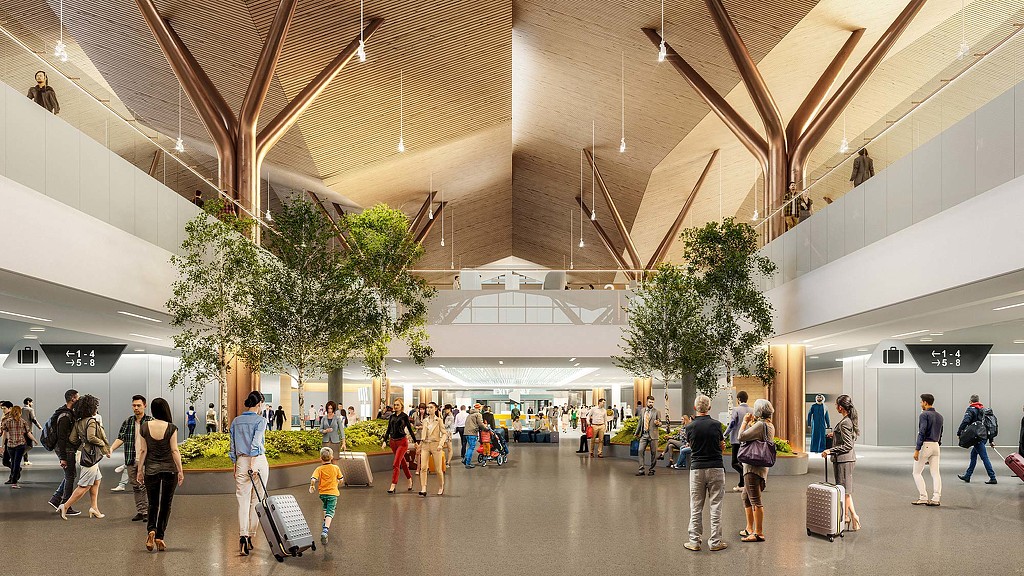 People with luggage in a large building.