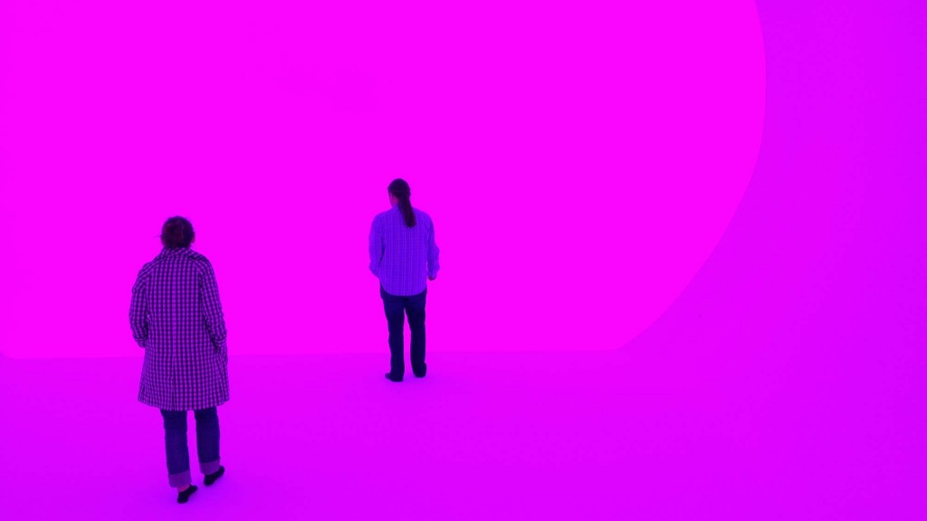 A couple of men looking at a pink circle.