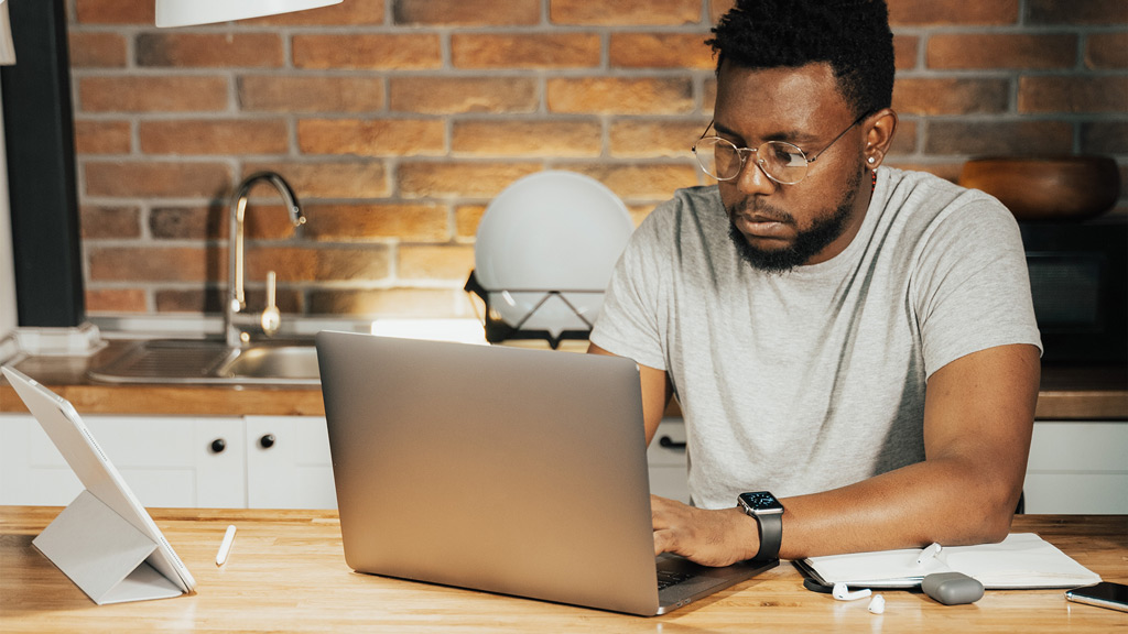 A man sitting at a table with a laptop.