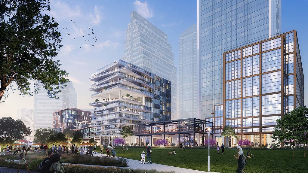 A group of people walking around a park in front of a building.