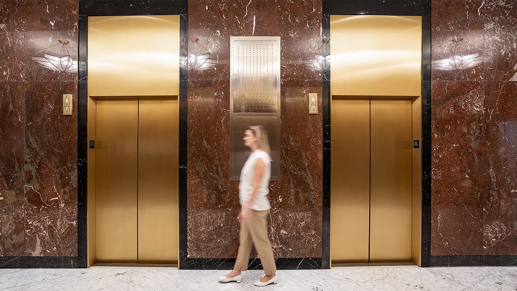 A person standing in front of a row of doors.