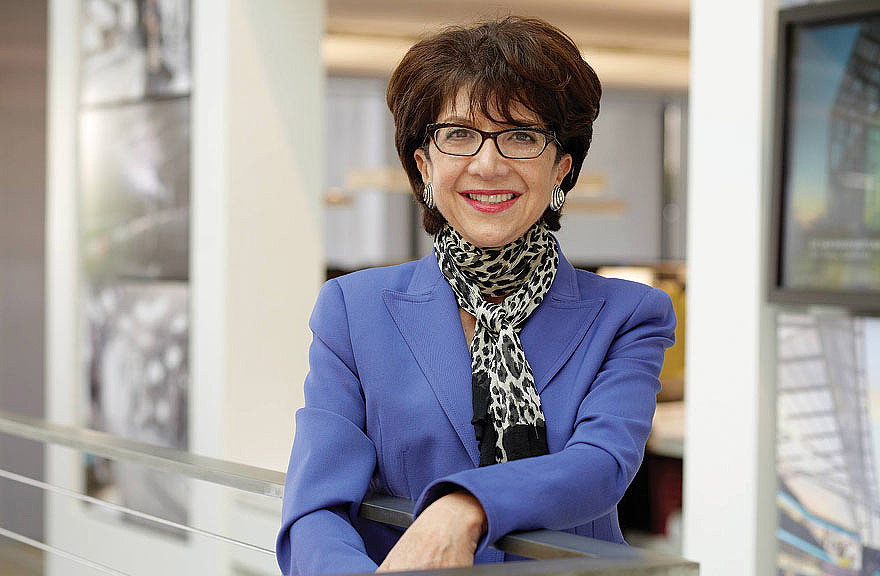 A person wearing glasses and a blue suit.