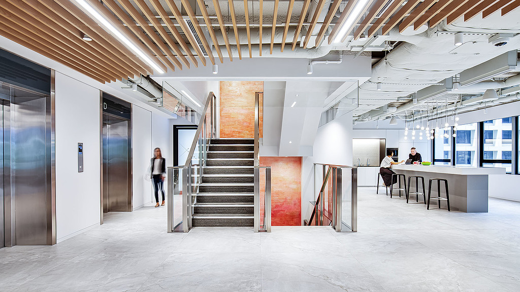 A room with a staircase and people.