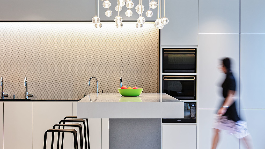 A person walking in a kitchen.