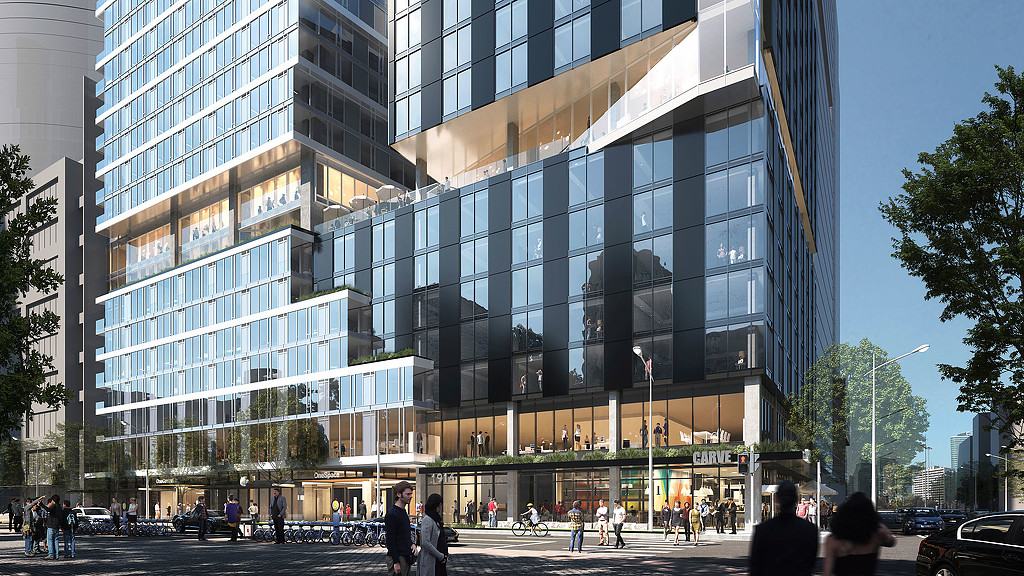 A large glass building with people walking around.