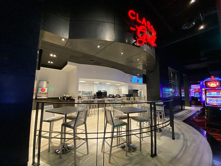 A restaurant with a bar and chairs.