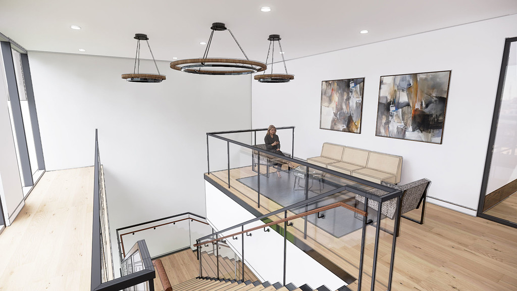 A person sitting on a chair in a room with art on the wall.