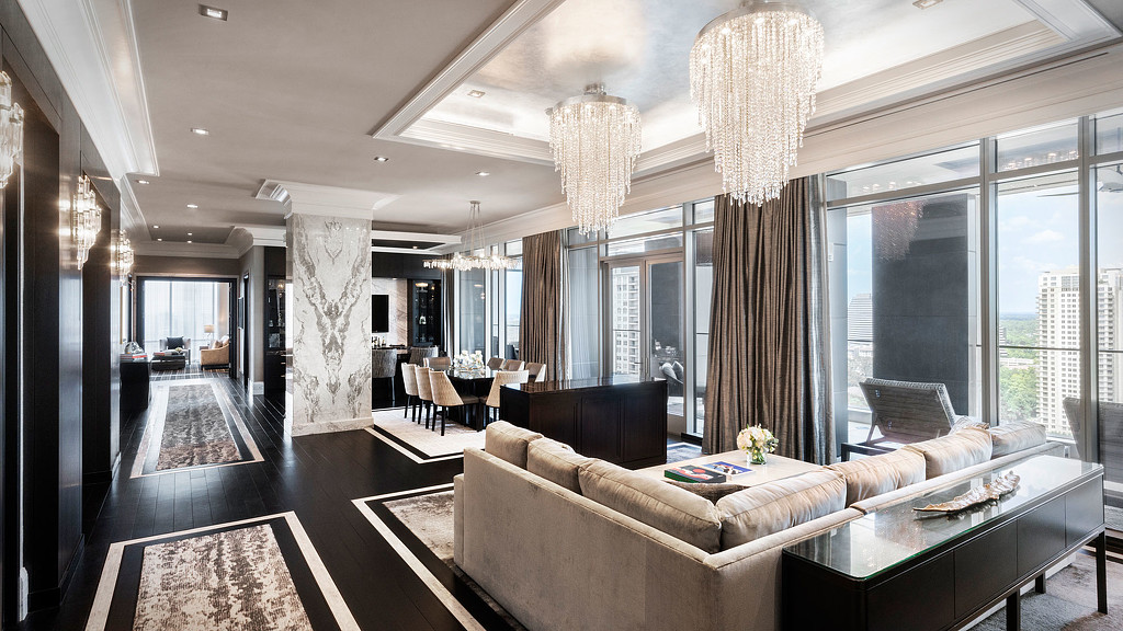 A large living room with a large chandelier and a large window.