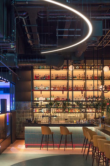 A room with a large glass ceiling and tables and chairs.