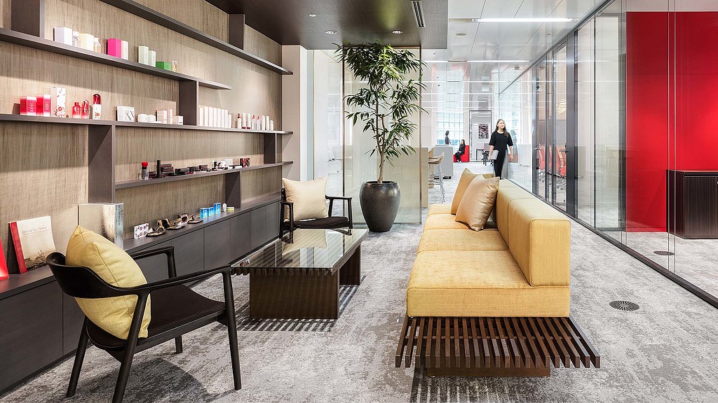 A room with a couch and chairs.