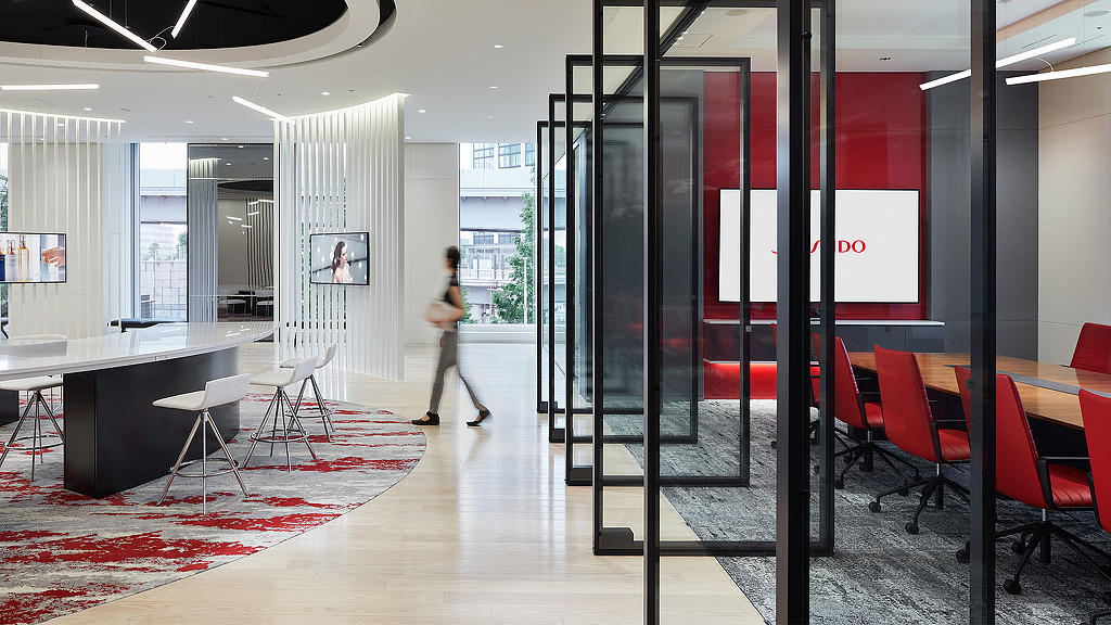 A person walking in a room with tables and chairs.