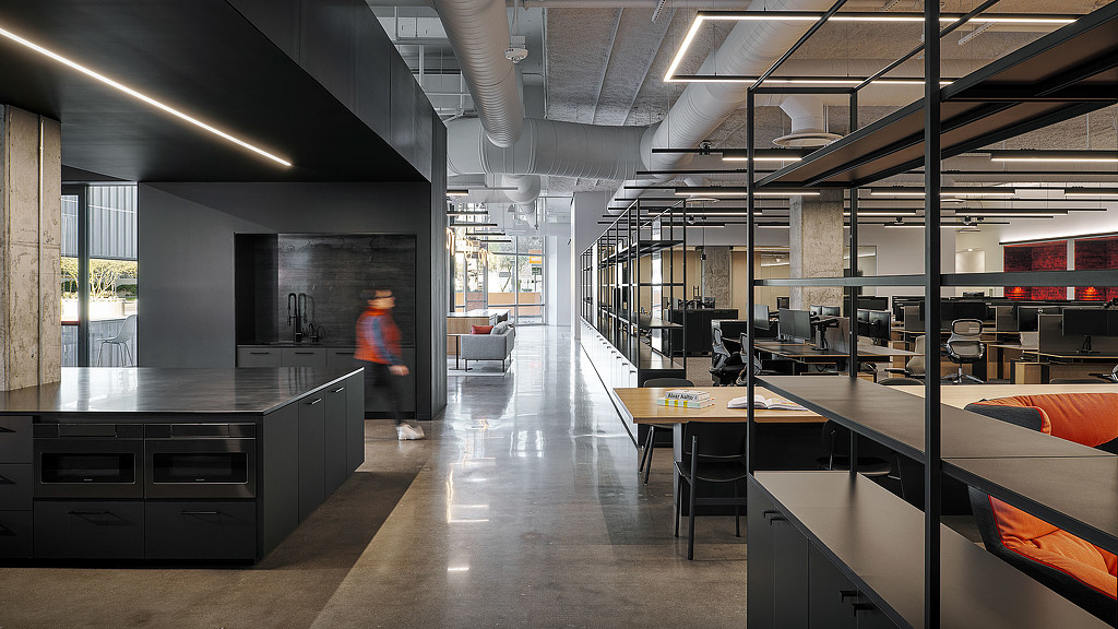 A person standing in a room with tables and chairs.