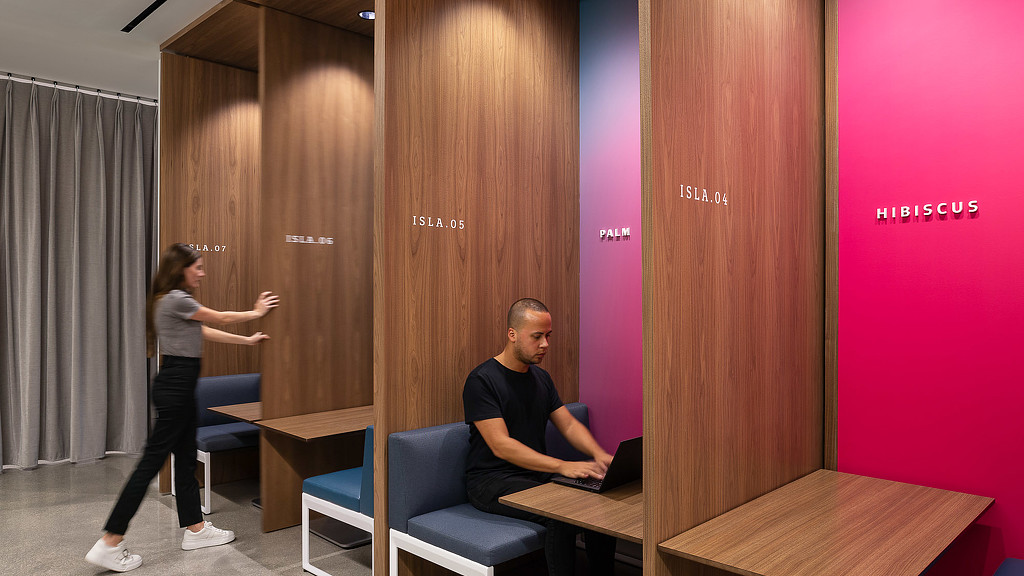 A man and a woman in a room with a table and chairs.