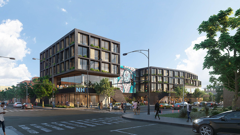 A street with cars and people on it and buildings in the back.