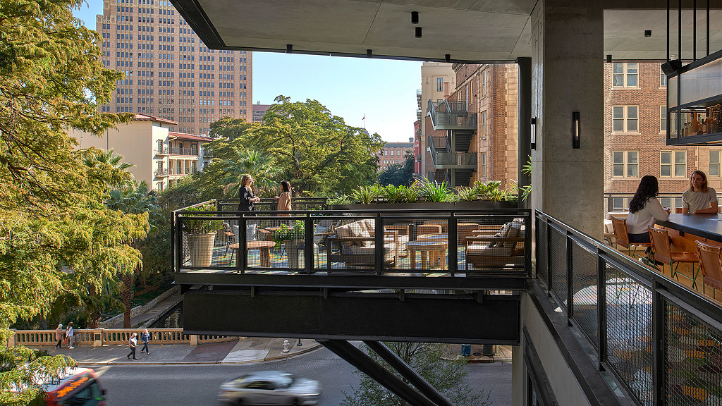 A group of people sitting at a table in a city.