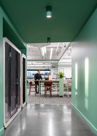 A couple of people sitting at a table in a room with green walls.