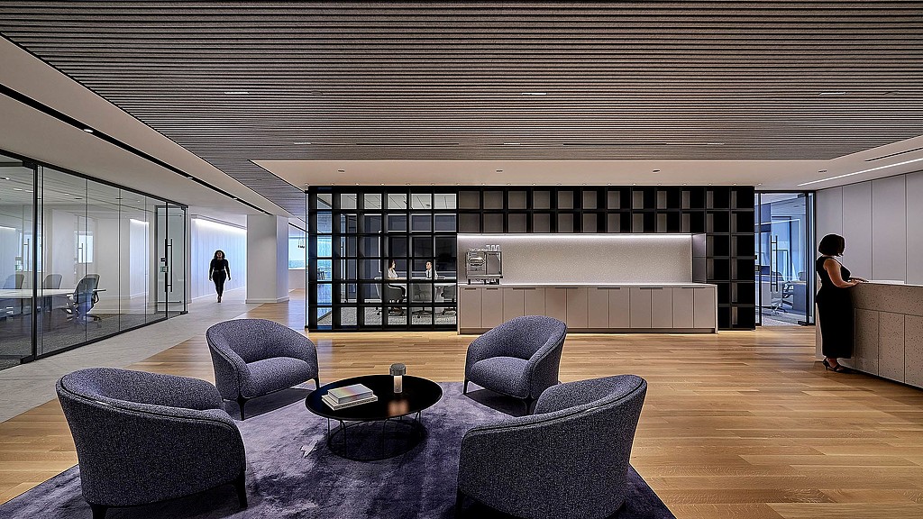 A room with a couch and chairs.