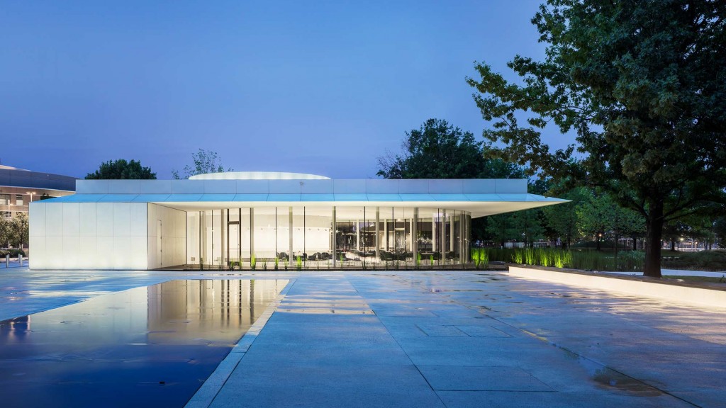 A building with a pool in front.
