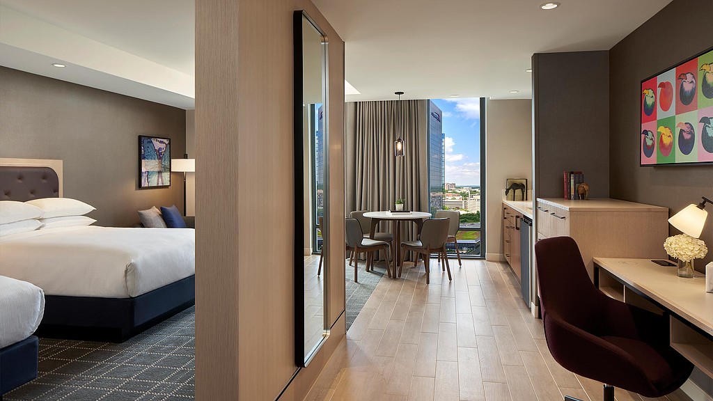 A room with a bed and desk.