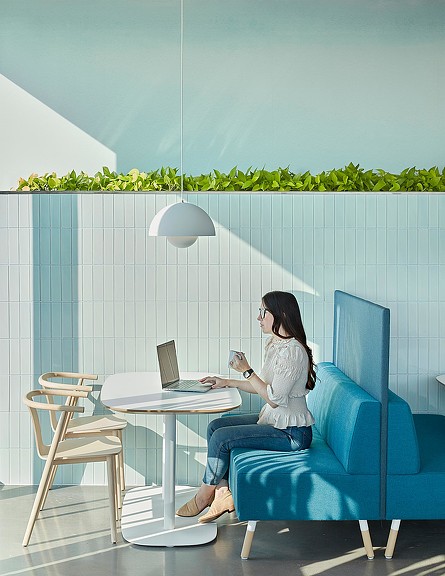 Woman working on laptop at JLL Charlotte cafe table