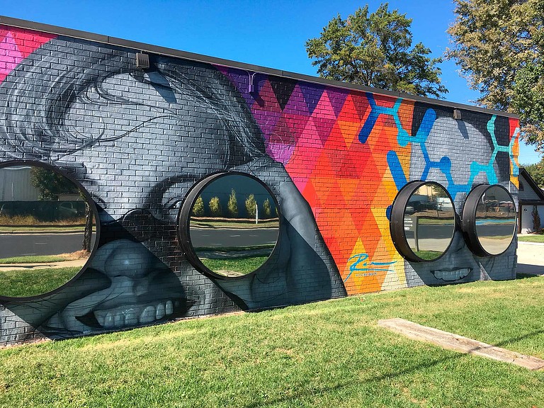 CBI Art Wall public mural of faces with 3D binoculars