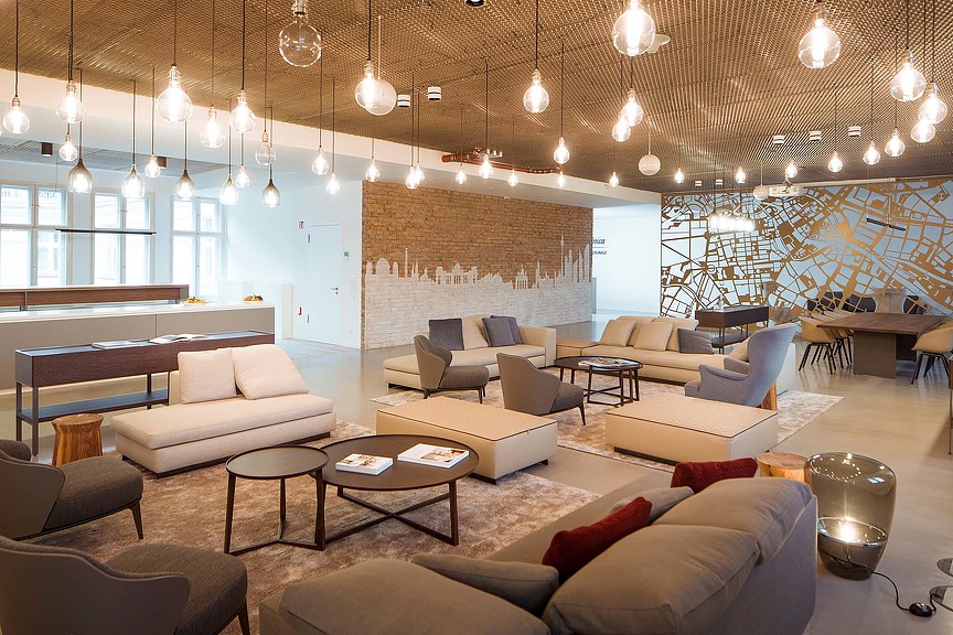 A room with a couch and chairs.