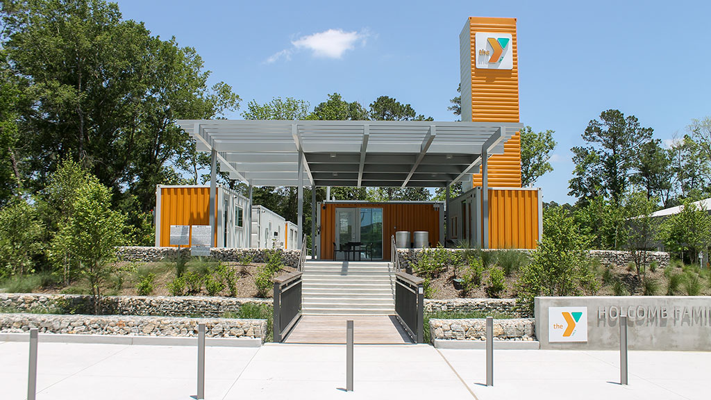 A covered area with benches and a building in the background.