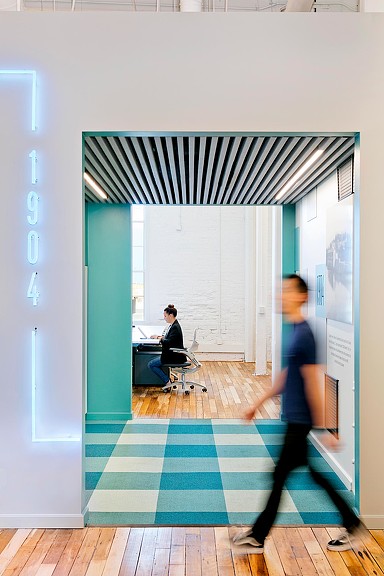 Man walking by turquoise open meeting room