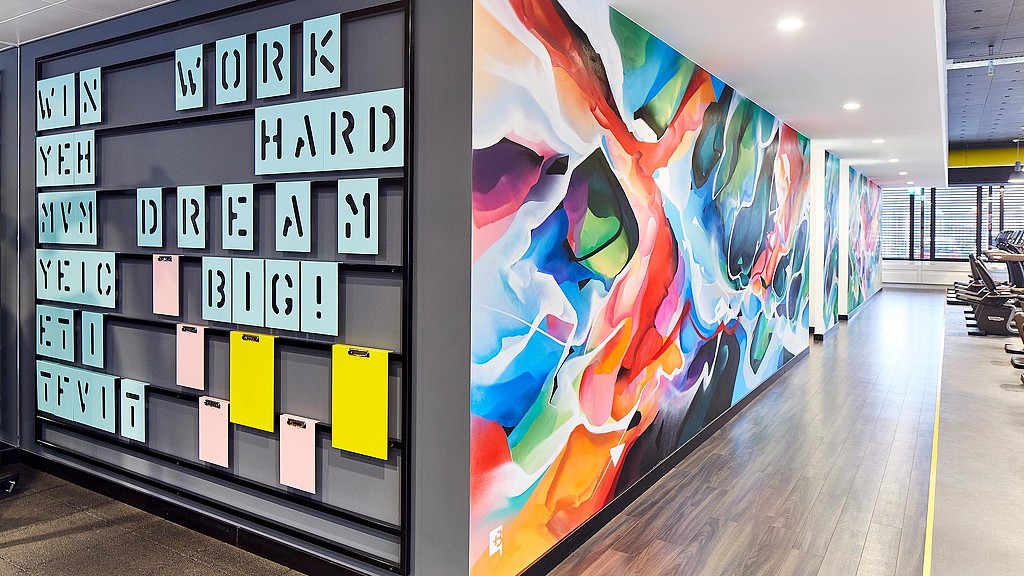 Graphic letters and mural on workplace gym wall