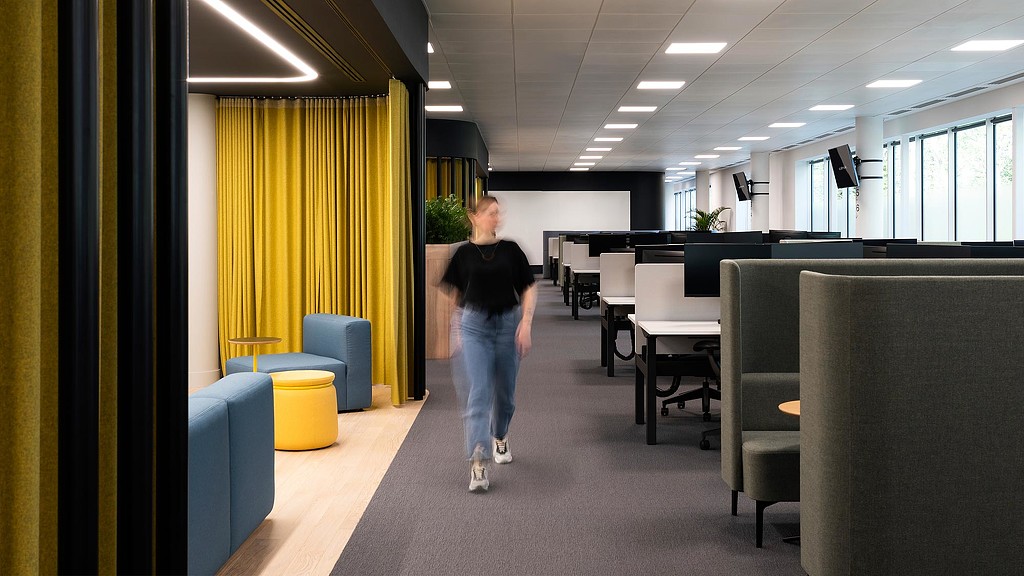 Woman walking through Citrix Cambridge office workspace