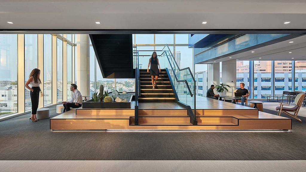 A group of people sitting on a staircase in a building.