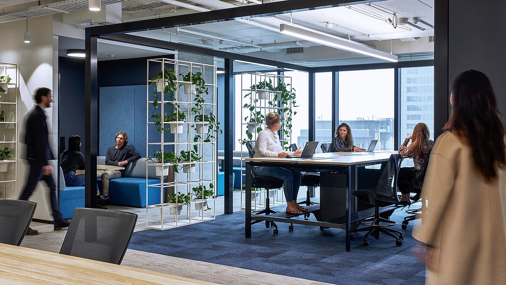 Employees in open meeting space with plants