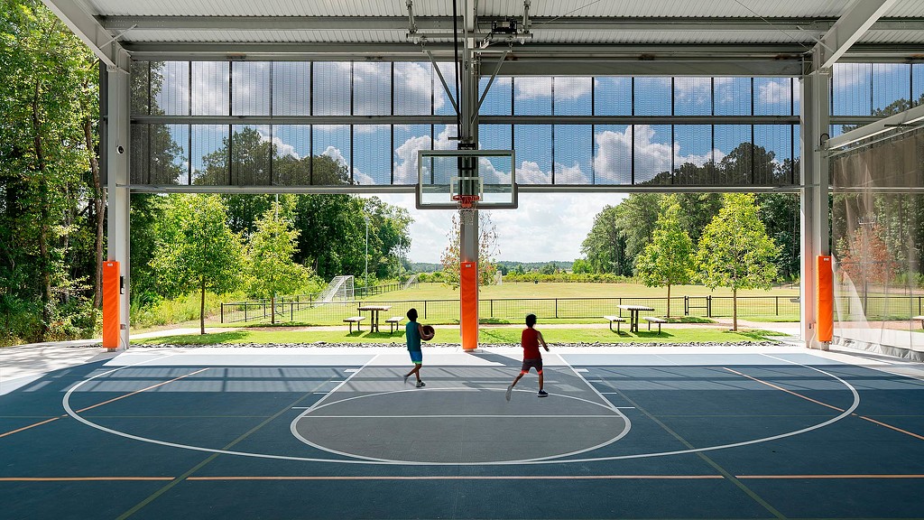 2 boys playing basketball in Holcomb Family YMCA indoor-outdoor basketball court